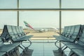 Barcelona, Ã¢â¬â¹Ã¢â¬â¹Spain - March 17, 2019: Empty chairs in the departure hall at airport on background of airplane taking off. Royalty Free Stock Photo